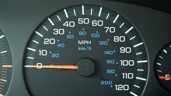 Close-up of a car speedometer, highlighting the balance of speed and delivery efficiency in quick-service restaurants.